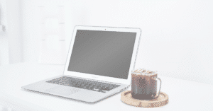 faded image of laptop beside an iced drink