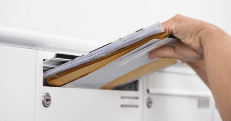 hand inserting mails into a mailbox