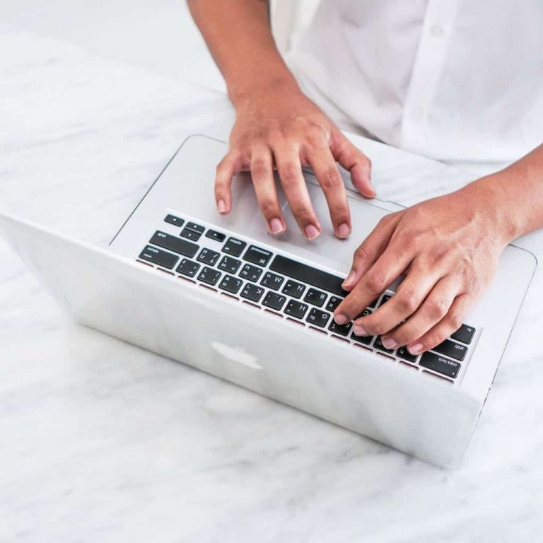 Business owner on laptop learning how to get cleaning business clients for their maid service