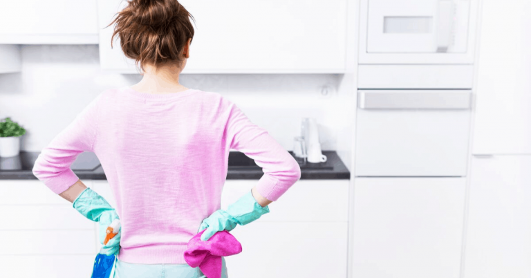woman looking at a pristine kitchen area after cleaning it
