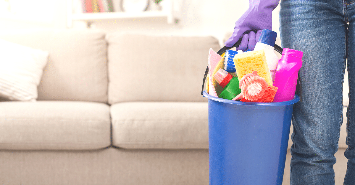 Close-up of woman holding a bucket of cleaning supplies. Training cleaning staff properly means quality cleans every time.
