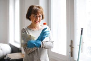 female cleaner holding cleaning supplies
