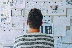 man looking at wall of business plans