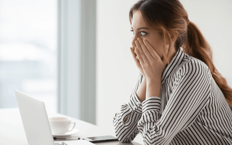 Shocked woman looking at laptop