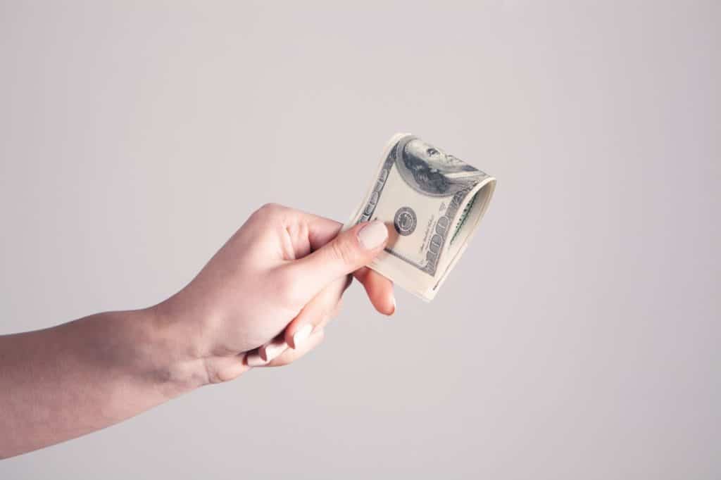 A cleaning customer hands over payment for cleaning services.