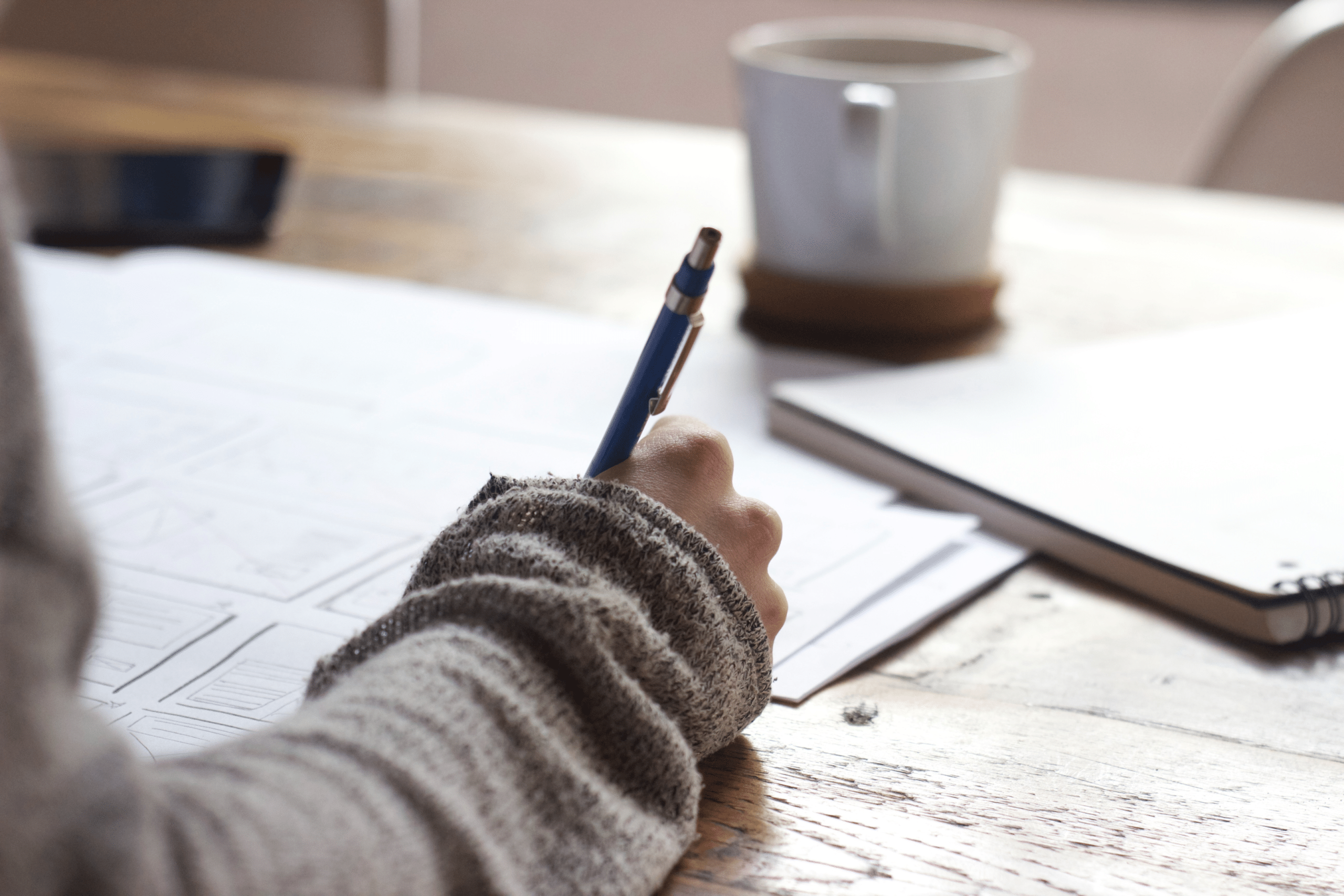 Person's hand writing with a pen